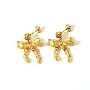 Detailed view of golden bow earrings with textured metal finish and round stud connector
