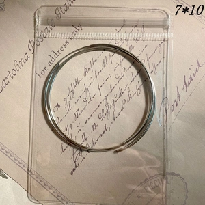 Detail view of small silver metal rings in a 7x10cm transparent anti-oxidation bag