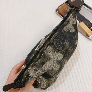 Nahaufnahme des goldfarbenen Schmetterlings-Jacquard-Stoffes der Kosmetiktasche