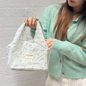 Detail of floral corduroy lunch bag with SOZAKKA woven label and soft fabric texture