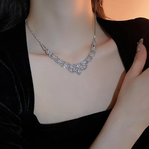 Gros plan du collier à pampilles en U avec strass en cristal étincelants sur un mannequin