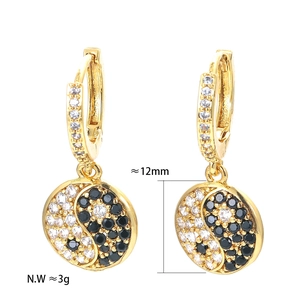 Detail view of gold Tai Chi hoop earrings with 12mm yin yang charms and zircon pavé