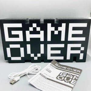 Detail view of Game Over pixel light showing USB cable and instruction manual with sound feature