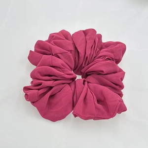 Detailed view of dark rose red chiffon hair scrunchie with soft pleated texture