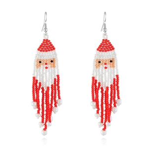 Detailed close-up of handmade beaded Santa Claus earrings with festive red and white fringes