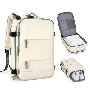 Vista detallada de mochila de viaje crema con compartimentos para ropa y calzado