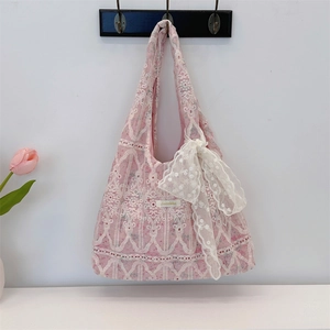Detailed embroidery on pink lace tote bag with white bow accent and floral motif