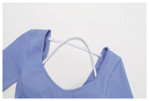 Detail of lavender yoga top with white criss-cross straps and seamless stitching