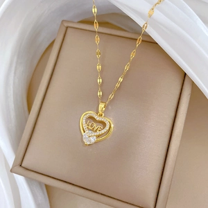 Goldene Herz-Halskette mit LOVE Gravur und Kristallanhänger auf elegantem Satinhintergrund
