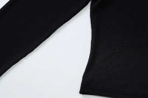 Gros plan sur la texture en tricot côtelé noir montrant les détails des coutures du haut
