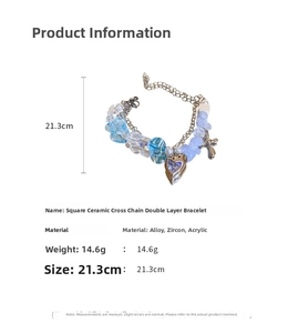 Detailed view of blue double-layer bracelet with cross charm and heart zircon pendant