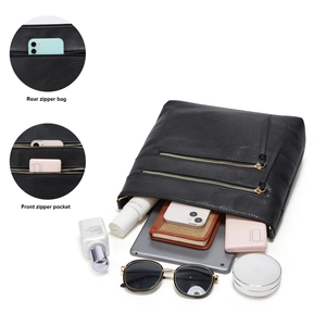 Detail view of large capacity black leather tote showing interior storage and zipper pockets