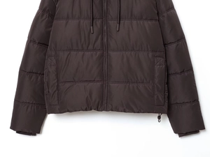 Detail of dark brown puffer jacket showing smooth zipper and adjustable drawstring hem