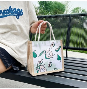 Detail of eco-friendly jute canvas tote bag with cute cartoon avocado print and cotton handles