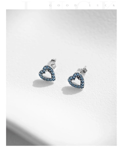 Macro shot of silver heart studs featuring blue turquoise stones and hollow design