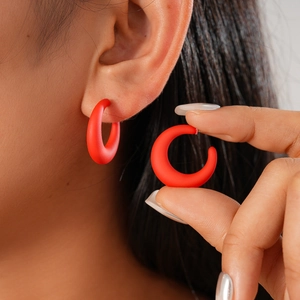 Matte red acrylic round C-shaped stud earrings shown on model and in hand