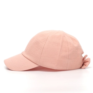 Detail view of pink cotton linen girl hat with bow decoration and breathable fabric texture