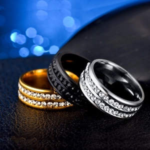 Detailed close-up of gold, black, and silver stainless steel rings with crystal inlays