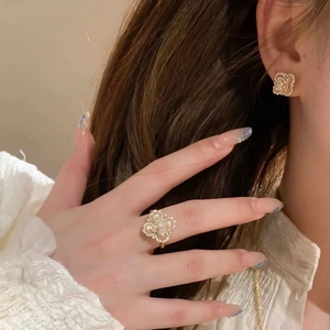Detail of gold flower jewelry set with pearls and zircons worn by a female model