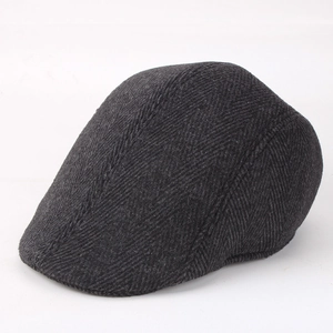 Detalle de gorra plana gris oscuro con tejido de espiga y textura de lana gruesa