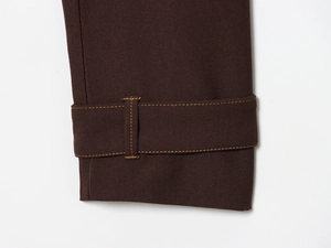 Close-up of deep brown twill fabric featuring decorative yellow contrast stitching details