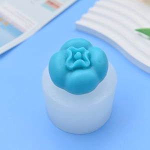 DIY persimmon-shaped silicone candle mold with finished candle on a blue background