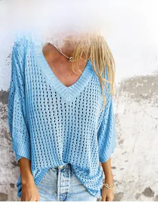 Detail eines blauen Lochstrick-Pullovers mit V-Ausschnitt und Rautenmuster
