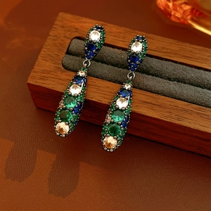 Gros plan détaillé de boucles d'oreilles vintage en gouttes avec pierres colorées