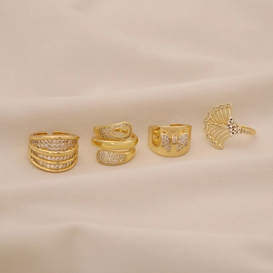 Set of four gold zircon rings featuring butterfly and ginkgo leaf geometric designs