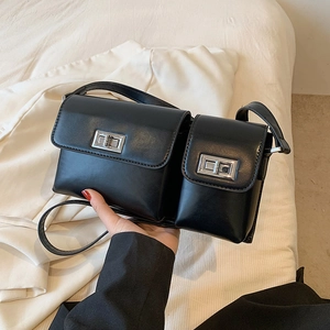 Close-up of black dual-pouch baguette bag with glossy PU leather and silver metal buckles