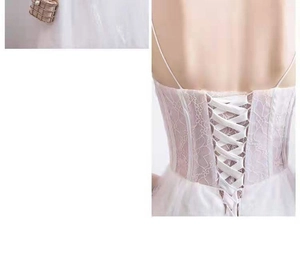 Détail d'une robe de mariée en dentelle avec laçage corset au dos et broderie florale