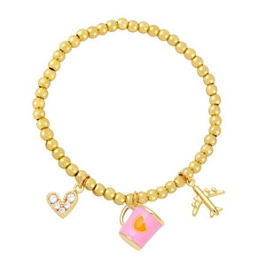 Golden beaded bracelet with heart, pink cup, and airplane charms on a white background