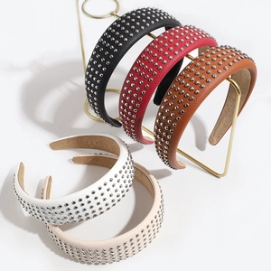 Fashionable rivet leather headbands in five colors displayed on a gold metal stand