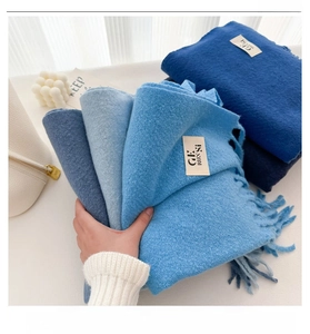 Close-up of soft blue wool blend scarves folded neatly with textured fabric detail