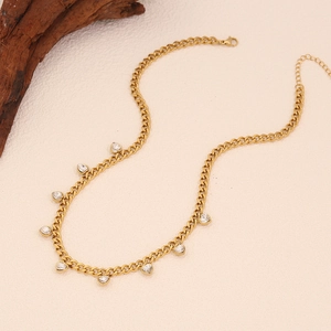 Detailed view of golden cuban chain necklace with sparkling heart-shaped zircon pendants