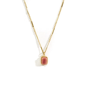 Dettaglio della collana in oro 14k con pendente rettangolare in pietra rosa e bordo grain