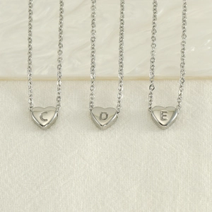 Three silver stainless steel heart necklaces with engraved letters C, D, and E on O-chains