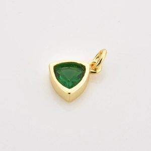 Macro detail of a minimalist gold triangle pendant set with a faceted deep green gemstone