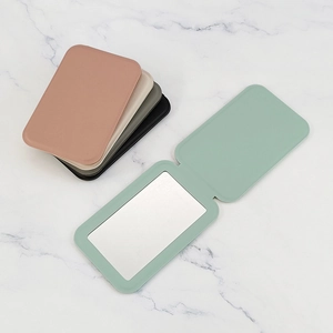 Portable PU leather folding makeup mirrors in multiple colors on marble background