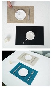 Close-up of woven PVC placemats in beige, black, and blue with heat-resistant texture