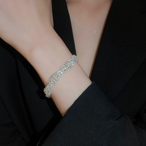 Detailed close-up of a silver twisted bangle with shimmering pavé rhinestones on wrist