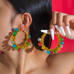 Festive Christmas hoop earrings with colorful beads and gold wire on a red background