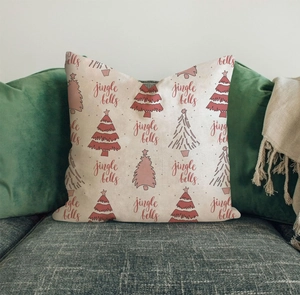 Weihnachts-Kissenbezug aus Leinen mit roten Bäumen auf grauem Sofa-Hintergrund