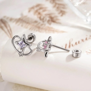 Star-shaped silver earrings with purple and pink gemstones shown from a close-up angle