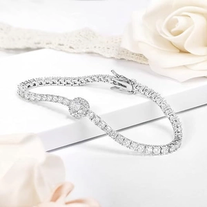 Detail of silver tennis bracelet with cubic zirconia and a central flower motif on lace
