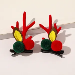 Detail showing plush Christmas reindeer antler hair clips with red balls and leaf accents