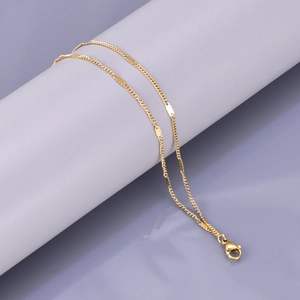 Minimalist double-layered gold bracelet with flat oval discs and lobster clasp on mirror