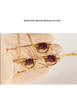 Detail shot of purple trapezoid gemstone pendant and earrings set with gold plating