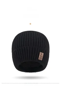 Close-up of black ribbed knit beanie featuring premium brown leather brand patch detail