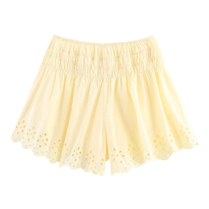 Detail showing pale yellow cotton shorts with delicate floral embroidery and scalloped edges
